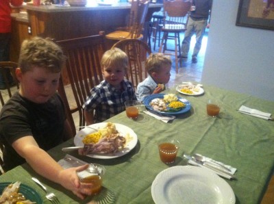 Harvey, Zion, and Lijah sitting at the Thanksgiving board