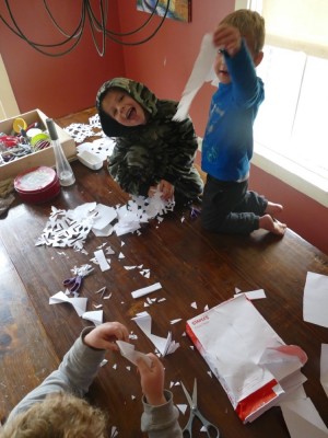 the boys making paper snowflakes at the kitchen table