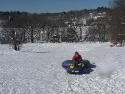 the boys on snow tubes on top of the sledding hill