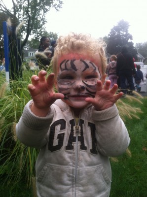 Lijah, face-painted like a tiger, showing his claws