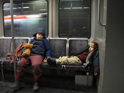 Harvey and Zion on the subway; Zion lying down