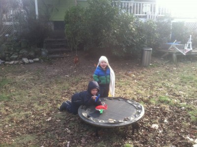 Zion and Lijah playing with toys on the little trampoline