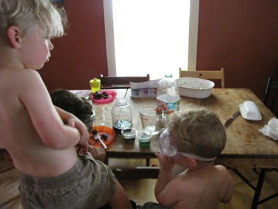 shirtless kids doing chemistry experiments at the kitchen table