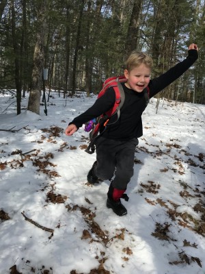 Zion in shirt sleeves running in the snowy woods