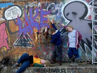 the boys posing in front of a grafitti'd water tower