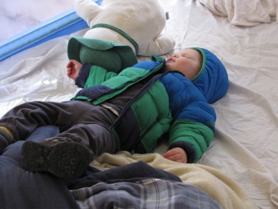 Lijah sleeping on his back in the bed, still wearing boots and coat