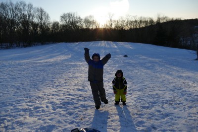 Harvey and Zion posing on the sledding hill as the sun sets