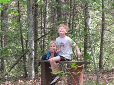 Zion and Nathan posing on a bench in the woods
