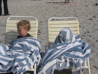 Lijah and Zion on beach chairs wrapped in towels