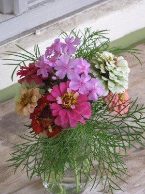 a small bouquet of flowers in a half-pint jar