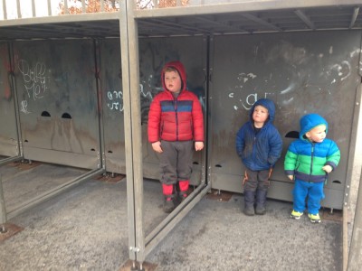 the three boys standing around under the half-pipe ramp at the skate park