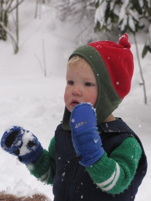 Lijah in his cute red hat eating snow