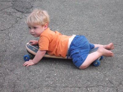 zion on his belly on a skateboard in the street