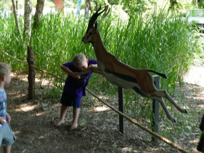 Zion pretending to eat the leg of a wooden antelope