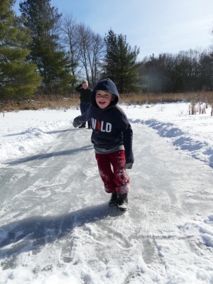 Zion sliding on a small cleared patch of ice on a snowy marsh