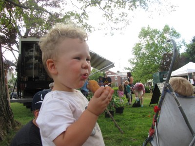Lijah eating a donut at the farmers market