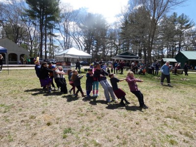 lots of kids on one side of a tug-of-war match at the 4H fairground