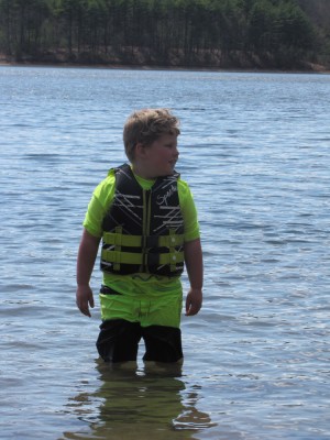 Harvey in his swimsuit and life jacket standing in the pond