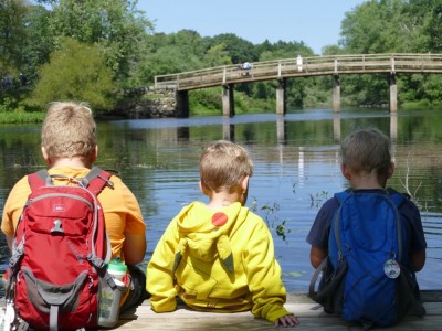 the boys sitting on a dock looking at the Old North Bridge