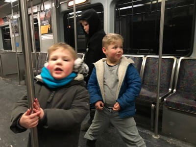 the boys standing up in an empty subway car