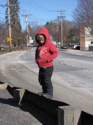 Zion balancing on the metal barrier along the side of the street