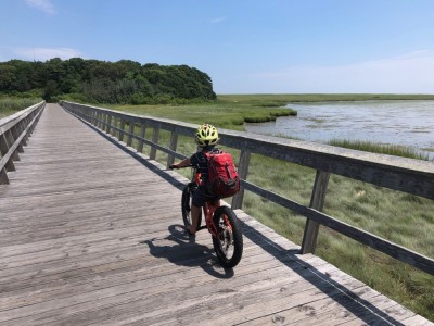 Elijah riding over a bridge over a salt marsh