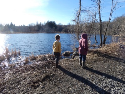 Zion and Elijah on a gravel path looking at a pond