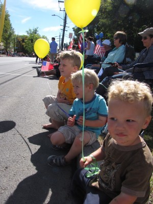 the boys with balloons waiting for the parade on the curb