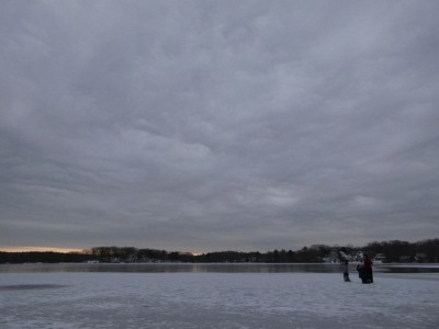 the boys on the ice at Freeman Pond under lots of lumpy overcast sky