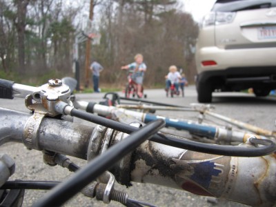 a close-up of dada's bike with the kids out of focus in the background