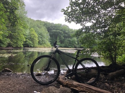 my mountain bike taking a break by a pond, under stormy skies