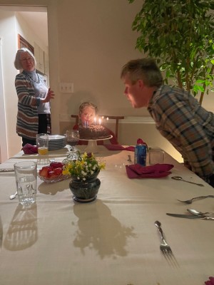 me and Elijah blowing out candles on our chocolate cake with Grandma looking on