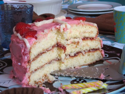 a half-eaten pink birthday cake