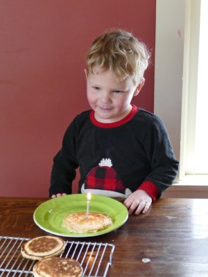 Lijah looking at a candle on his pancake