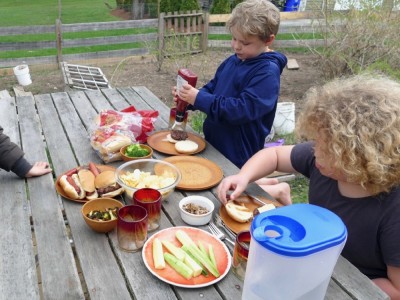 eating hamburgers and hot dogs at the picnic table