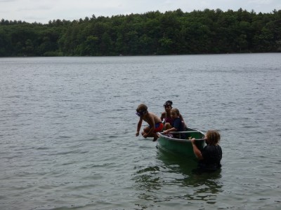 Elijah jumping out of the canoe, with Harvey holding it