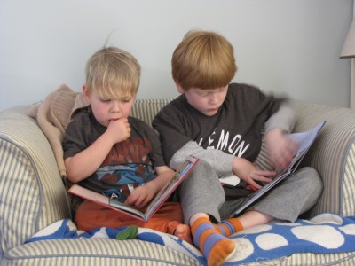 Zion and Nathan reading (each their own book) on the chair
