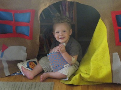 Lijah in the playhouse looking at a book