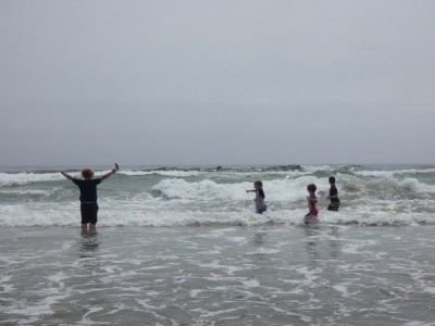kids thigh-deep in the waves, Harvey raising his arms in triumph