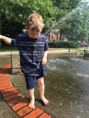 Lijah playing at the edge of a fountain
