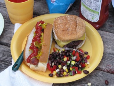 hot dog, cheeseburger, and corn and bean salad on a plate
