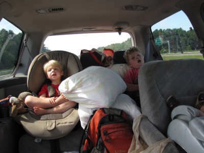 Zion and Harvey comfy among camp supplies in the back seat, singing