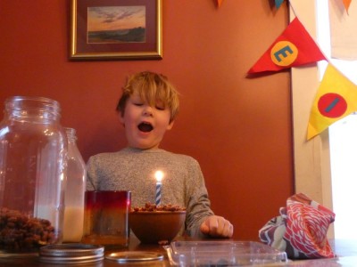 Elijah getting ready to blow out a birthday candle in his cereal