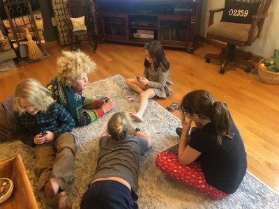 the boys sitting on the floor playing Uno with their second cousins