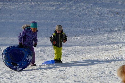 Zion and Nisia climbing back up the sledding hill