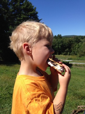 Zion eating a smore in the daylight in the country