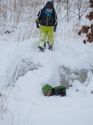 Elijah and Zion jumping off a big rock into deep snow