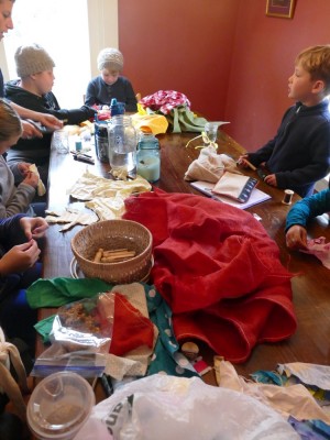 kids working at the table around piles of fabric