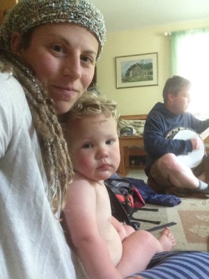 Leah holding Lijah on her lap, Dan playing banjo in the background