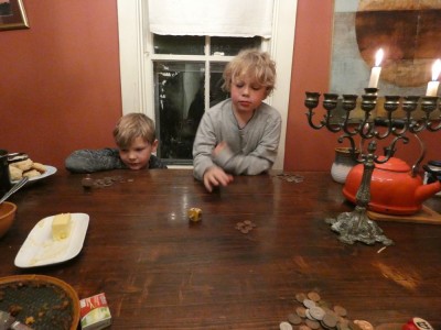 Zion and Elijah playing driedel at the kitchen table